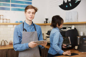 Young barista takes orders from customers