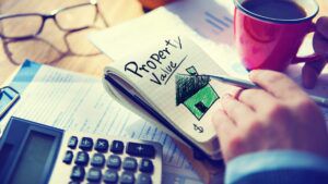 Man sketching 'Property Value' on notepad, challenge business rates concept