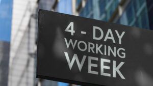 Sign outside office building saying '4-Day Working Week', four-day week concept