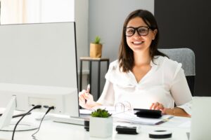 small business bookkeeping software concept. Smiling bespectacled woman doing accounts
